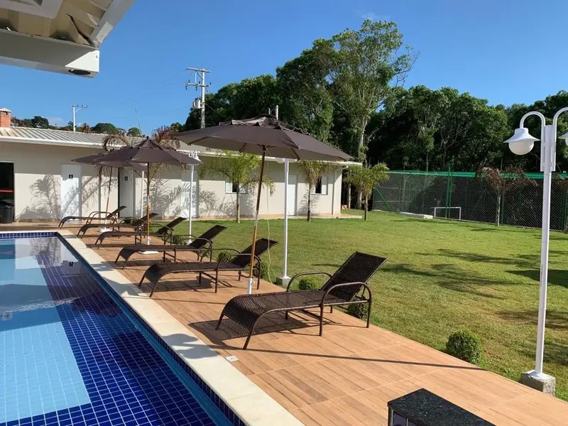 Piscina com deck de madeira e espreguiçadeiras