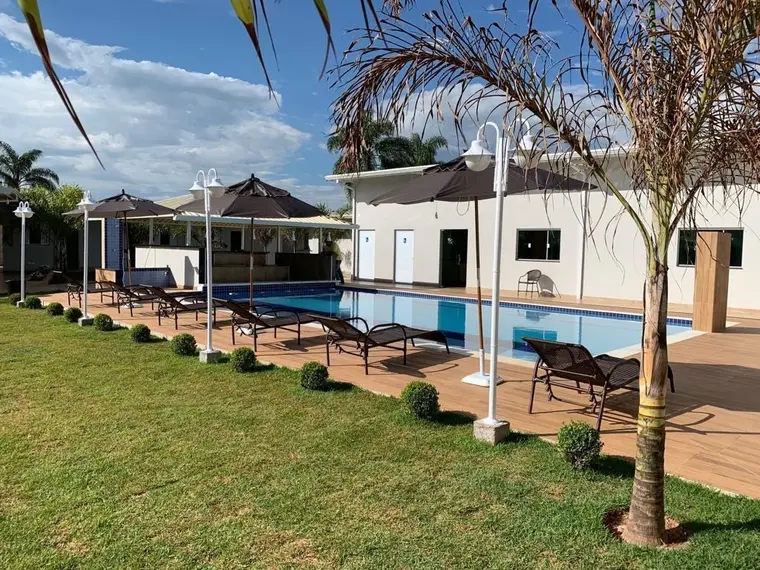 Vista geral da unidade, com a piscina, as palmeiras e a construção ao fundo