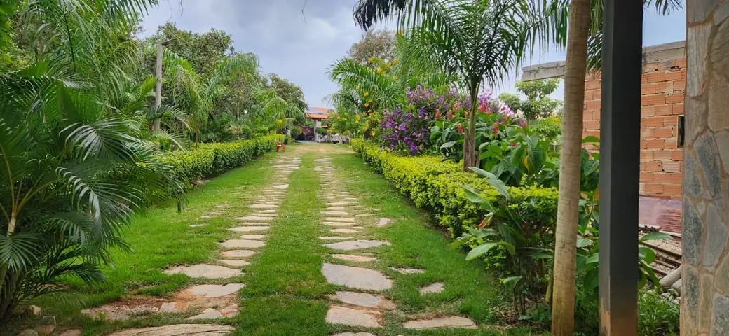 Caminho de pedras entre canteiros floridos em uma unidade feminina da rede