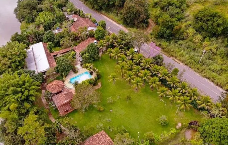 Vista aérea do terreno, mostrando as construções, a piscina e a mata em volta