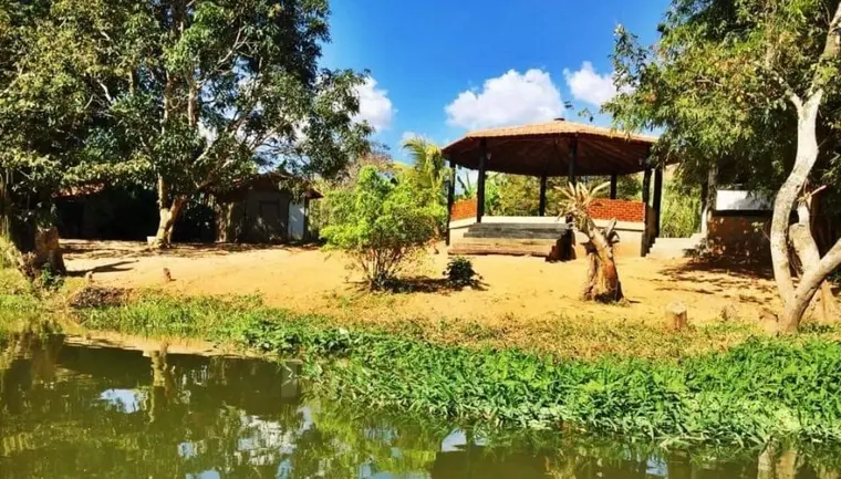Lago com vegetação nas margens e quiosque à beira da água