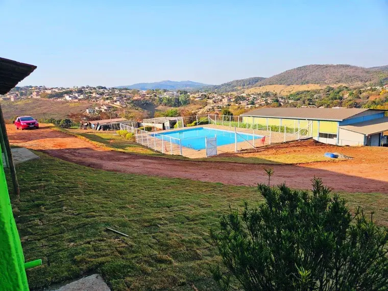 Vista do terreno mostrando a piscina cercada e o galpão coberto ao fundo