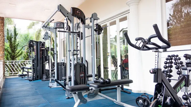 Academia envidraçada com aparelhos de musculação e bicicletas