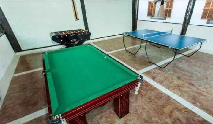 Salão de jogos com mesa de sinuca e mesa de tênis de mesa