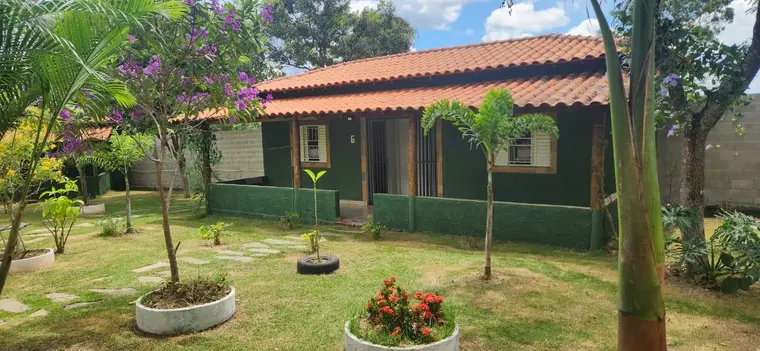 Fachada lateral da sede, com gramado e vasos de plantas
