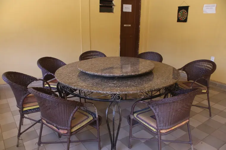 Espaço de convivência interno com mesa redonda e oito cadeiras