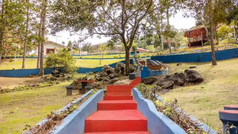 Escadaria larga entre canteiros de pedras e jardim