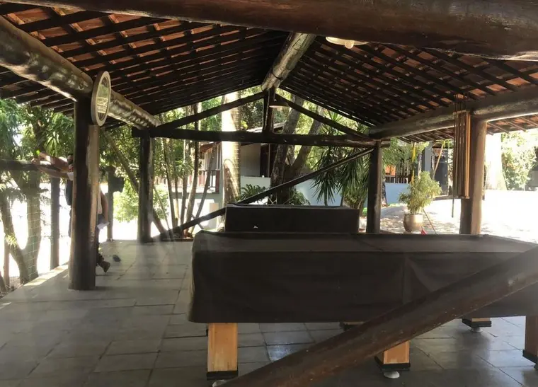 Salão de jogos coberto, com mesa e vista para a área externa