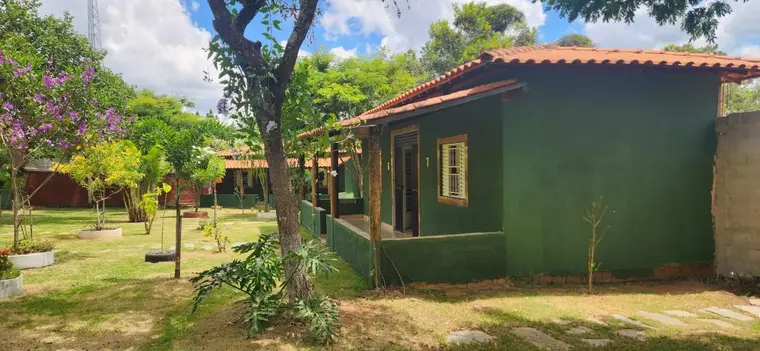 Área externa arborizada junto à sede, com bancos e sombra