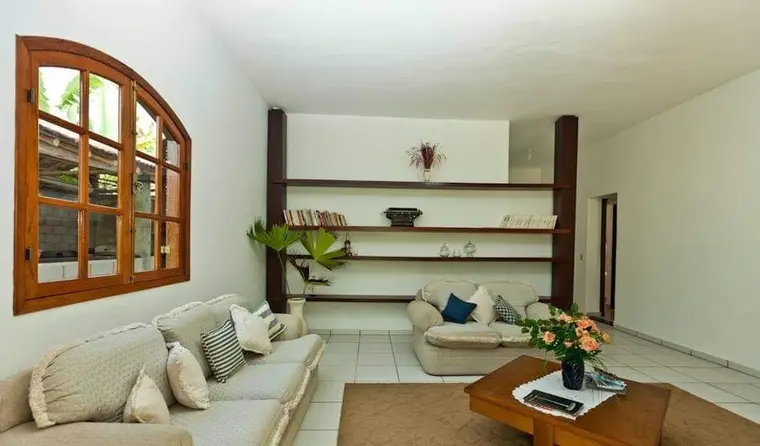 Sala de estar com sofá, estante e janela em arco