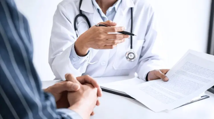 Médico anotando em uma prancheta durante uma consulta