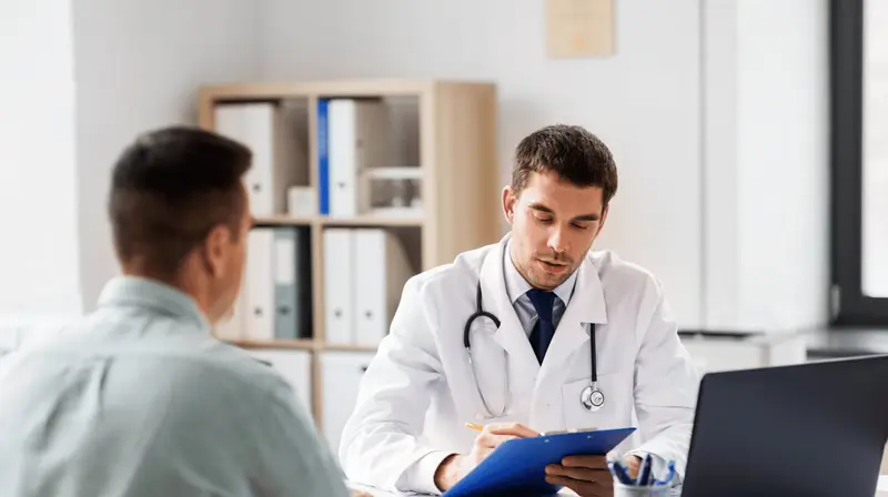 Profissional de saúde de jaleco branco conversando com um homem durante um atendimento